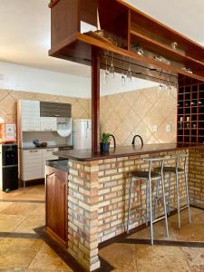una cucina con bancone in mattoni e sgabelli di Casa Caju a Aracati