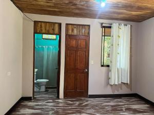 een lege kamer met twee deuren en een toilet bij PachaMama Bio in Tamarindo