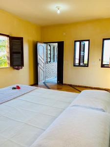 una camera con due letti e una porta con finestre di Casa Caju a Aracati