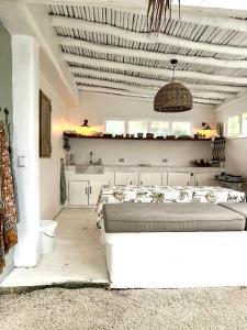a white room with a bed and a kitchen at My Island Home Vanuatu in Eton