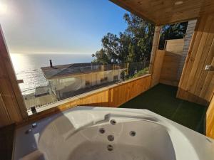 La salle de bains est pourvue d'une baignoire et offre une vue sur l'océan. dans l'établissement Al Mar Cabañas, à Viña del Mar