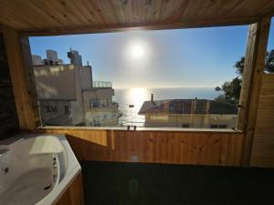 La salle de bains est pourvue d'une fenêtre offrant une vue sur l'océan. dans l'établissement Al Mar Cabañas, à Viña del Mar