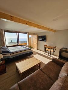 un salon avec un canapé, un lit et une table dans l'établissement Al Mar Cabañas, à Viña del Mar