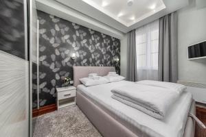 Schlafzimmer mit einem Bett mit einer schwarz-weißen Tapete in der Unterkunft Wolf Apartments Kopaonik in Kopaonik