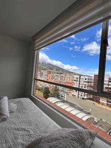 een slaapkamer met een groot raam met uitzicht op de stad bij Luxury, Comfort central área in Pasto