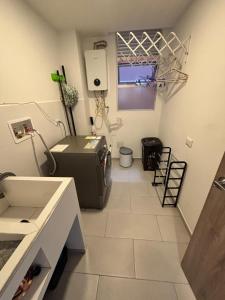 een badkamer met een wastafel en een wasmachine in een kamer bij Luxury, Comfort central área in Pasto