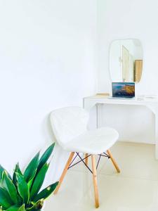 Ein weißer Stuhl neben einem Schreibtisch mit Spiegel in der Unterkunft เดอะซันเซ็ท บางแสน Exclusive Top Floor in Chon Buri