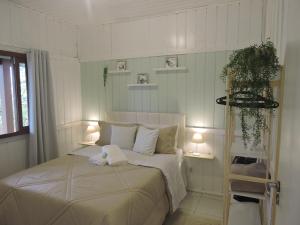 a bedroom with a bed with two lights on it at Recanto da Natureza in Imbituba