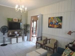 a living room with a couch and a tv at Recanto da Natureza in Imbituba