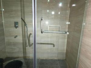 eine Dusche mit Glastür im Badezimmer in der Unterkunft Revigore Oniru 1 in Lagos