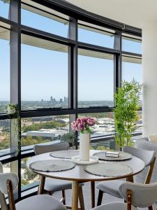 a dining room with tables and chairs and large windows at The Sky Perch in Sydney