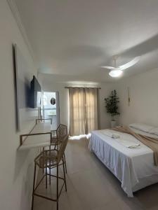 a bedroom with a bed and a table and chairs at Pousada do Moinho in Cabo Frio