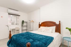 ein Schlafzimmer mit einem Bett mit einer blauen Decke in der Unterkunft Luxury Private House near Beach in Costa da Caparica