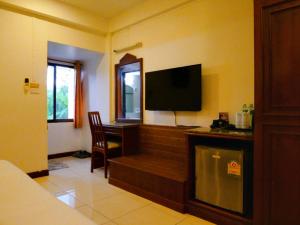 a room with a television and a desk with a chair at Hua Lin Inn in Chiang Mai