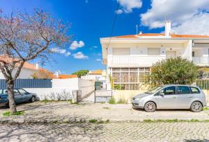 ein weißes Auto, das vor einem weißen Haus parkt in der Unterkunft Luxury Private House near Beach in Costa da Caparica