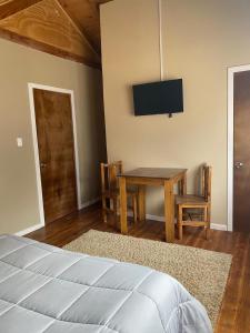 una camera da letto con un letto, un tavolo e una televisione di Casona Pretton a Valparaíso