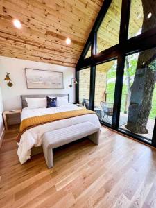 una camera da letto con un letto grande e grandi finestre di Private Modern Treehouse Retreat in the Forest a Cross Plains