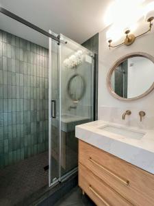 un bagno con doccia, lavandino e specchio di Private Modern Treehouse Retreat in the Forest a Cross Plains