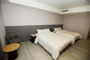 une chambre d'hôtel avec deux lits et une chaise dans l'établissement Tai Shinu Hotel, à Touliu 80 autres photos