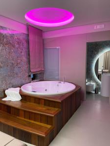 a bathroom with a large tub with a pink ceiling at Hotel 2000 in Giugliano in Campania +72 photos