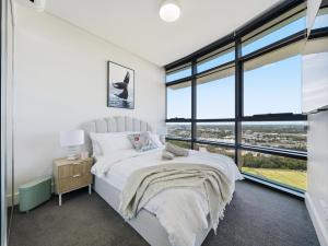 a bedroom with a bed and a large window at The Sky Perch in Sydney