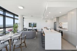 an open kitchen and living room with a table and chairs at The Sky Perch in Sydney +16 photos