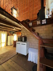 a kitchen with a stove and a staircase in a room at Chalé dos Alves in Morro Azul