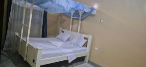 Cette chambre comprend un lit blanc à baldaquin. dans l'établissement Marially Luxury 4, à Malindi
