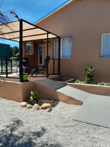 a house with a patio and a chair in front of it at Cabañas Los Teros in Aluminé +17 photos