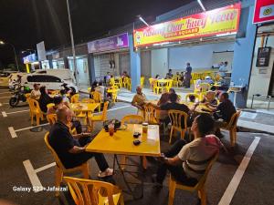 eine Gruppe von Menschen, die an Tischen in einem Restaurant sitzen in der Unterkunft The Duta Loft in Bandar Puncak Alam