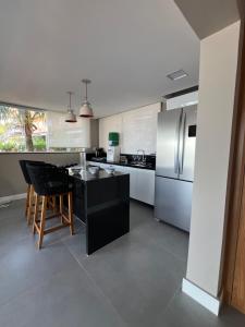 eine Küche mit schwarzer Theke und Kühlschrank in der Unterkunft Angra pé na areia in Angra dos Reis + 12 Fotos