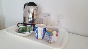 a tray with two coffee cups and a blender at Het Uilenbos in De Koog