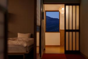 een slaapkamer met een bed en een raam bij 樹-Itsuki- "岩風呂付 rockbath" in Hakone