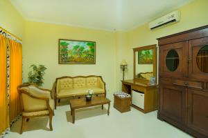 a living room with a couch and a table and a cabinet at Diana Hotel Jogja in Yogyakarta
