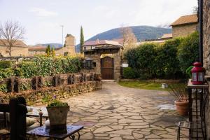 een stenen loopbrug naar een huis met een deur bij Hotel Boutique Barosse Family & Pet Friendly Roo in Jaca