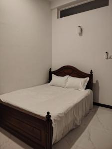 a bed with white sheets and pillows in a room at Cinnamon Shade by Achievers in Negombo