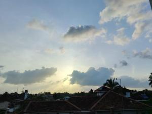 a cloudy sky with roofs in a city at Cinnamon Shade by Achievers in Negombo