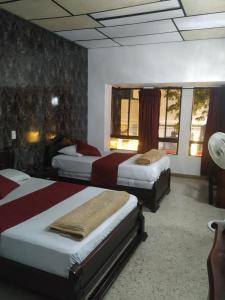ein Hotelzimmer mit zwei Betten in einem Zimmer in der Unterkunft Hotel Ejecutivo in Pereira