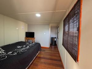 een slaapkamer met een bed en een groot raam bij Refugio de luna Coquimbo in Coquimbo