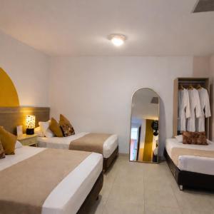 a hotel room with two beds and a mirror at Casa de Pinos Hotel Boutique in Bucaramanga +19 photos