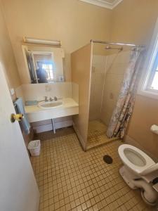 un bagno con lavandino, doccia e WC di Cadney Park Accommodation a Coober Pedy