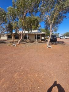 l'ombra di una persona che si trova di fronte a una casa di Cadney Park Accommodation a Coober Pedy