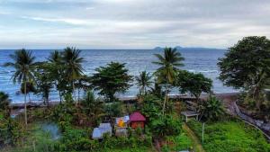 a small house on the beach near the ocean at Sirus Base Camp Tagulandang in Kisihang
