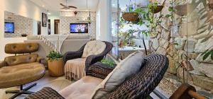 a salon with wicker chairs and a stone wall at Casa Ponta de Campina in Cabedelo