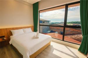 a bedroom with a bed and a large window at Crosview in Kampung Sepetang