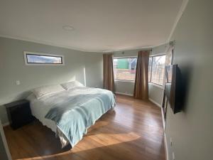 een slaapkamer met een bed en een flatscreen-tv bij Great house in Punta de Lobos in Chacurra