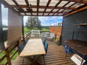 een houten terras met een tafel en stoelen erop bij Great house in Punta de Lobos in Chacurra