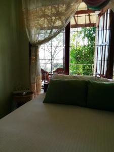 a bedroom with a bed and a large window at SiSi Place in Dickwella