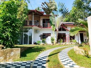a house with a checkered walkway in front of it at SiSi Place in Dickwella