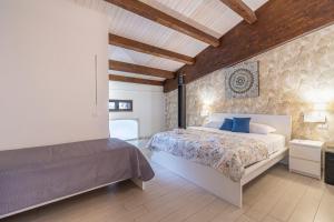 ein Schlafzimmer mit einem großen Bett und einer Steinwand in der Unterkunft Le Saline Rooms Marzamemi in Marzamemi